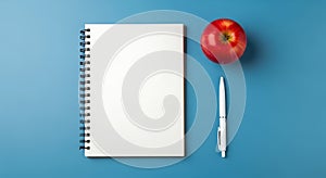 Notebook, Apple, and Pen on Blue Background - Top View, Education Concept