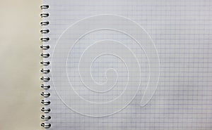 Spiral notebook blank squared white pages. First blank notepad page close up view