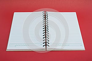 Spiral notebook on red background.