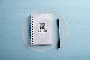 Spiral notebook with a Time for action sign spelled in it