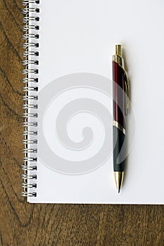 Spiral notepad, pen on wooden desk