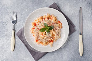 Spiral pasta mixed with cherry tomatoes and tomato sauce on a plate