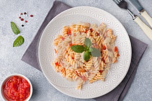 Spiral pasta mixed with cherry tomatoes and tomato sauce on a plate