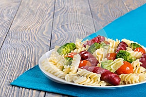 Spiral Pasta salad with broccoli and grilled sausages , close u