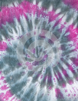 Spiral pattern in tie dye style made by hand on white fabric in gray-red color. Flat lay