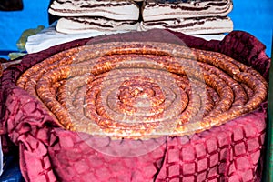 Spiral sausage coil, called srpska domaca kobasica, raw, uncooked, a fresh sausage on dispplay on a Serbian market. photo