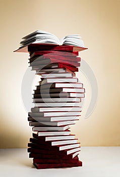 A spiral of stacks of books in the form of DNA and an open textbook at the top. photo
