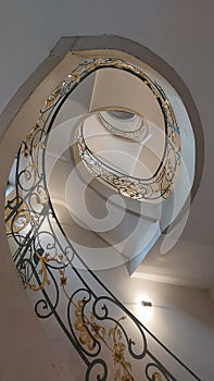 Spiral staircase with art nouveau handrail in wrought iron