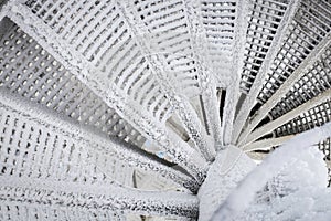 The spiral staircase is covered in snow. Dangerous descent