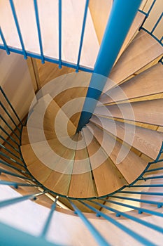 Spiral staircase, forged green handrail and wooden steps in modern home