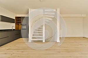 a spiral staircase in a kitchen leading to a white