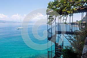 Spiraling staircase leading towards the vast ocean in Corfu, Greece