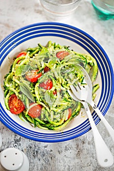 Spiralled courgette with green pesto and cherry tomatoes photo