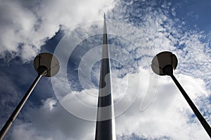 Spire of Dublin with converging street lights blue sky and clouds