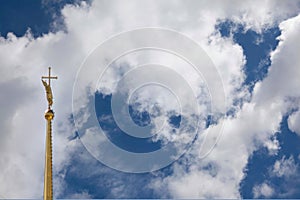 The spire of the Peter and Paul Cathedral in St. Petersburg against the background of a cloudy sky.