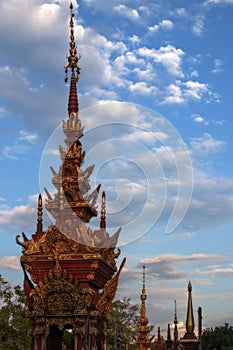 Spires of the Buddhist temples on the background of blue sky with clouds