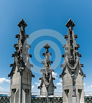 The spires of the historic cathedral in Fribourg under a blue sky with white clouds