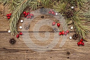 Spirit Christmas background. Fresh dog-rose berries, ball candies, pine branches and cones, artificial snow. Nature decorations,