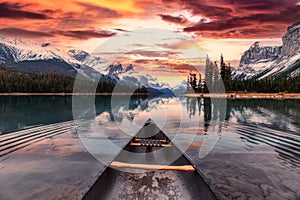 Spirit Island with canoe and colorful sky over canadian rockies on Maligne Lake in the sunset at Jasper national park