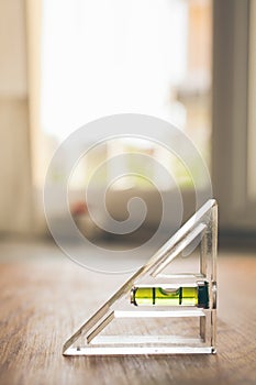 Spirit level tool on wooden background. Close up view of construction tool. Bubble spirit level. Industry and construction.