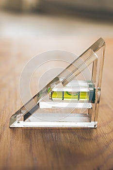 Spirit level tool on wooden background. Close up view of construction tool. Bubble spirit level. Industry and construction.