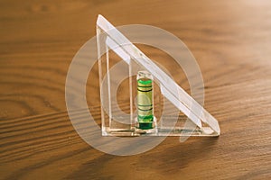 Spirit level tool on wooden background. Close up view of construction tool.