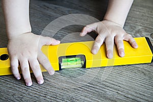 Spirit level in young boy hand - child with waterlevel
