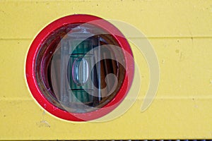 Spirit Yellow level tool close-up in red circle, for industrial background or texture