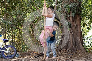 Spirited Girl Climbing Rope with Brother& x27;s Support.