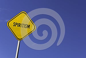 Spiritism - yellow sign with blue sky background photo