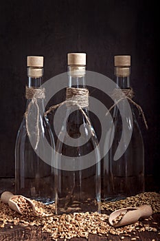 Spirits or vodka from wheat in shot glass with wheat grains and ears