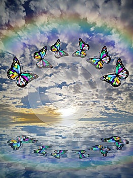 Spiritual background for meditation with butterflies, stormy clouds and rainbow in sea reflection