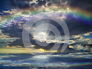 Spiritual background for meditation with stormy clouds and rainbow in sea reflection