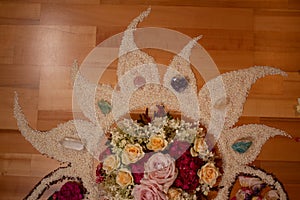 spiritual ceremony with flowers and rice in the shape of a moon, sun, fire and star on a wooden floor, shaman