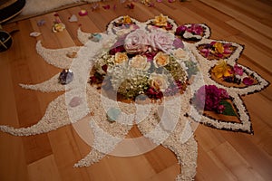 spiritual ceremony with flowers and rice in the shape of a moon, sun, fire and star on a wooden floor, shaman