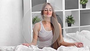 Spiritual domestic young woman meditating at bedroom with closed eyes. Medium shot on RED camera