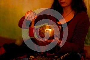 Spiritual girl immersed in meditative sounds of tibetian bowl.