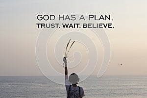 Spiritual inspirational quote - God has a plan. Trust wait and believe. On soft calm sunset light background over horizon.