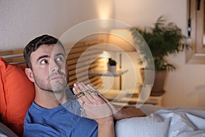 Spiritual man praying in bed