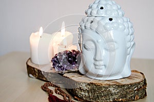 Spiritual ritual meditation face of Buddha ametist candles on wooden white background