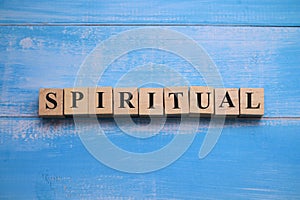 Spiritual, text words typography written on wooden block against blue background, life and business motivational inspirational