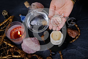 Spiritualistic Experience, esoteric table, female fortuneteller\'s hand holding and using glass ball crystal, candles burn,