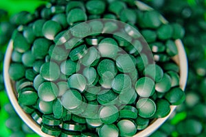 Spirulina pills in a round bowl..Spirulina algae tablets. Vitamins and dietary supplements.Super food .Food supplements
