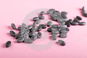 Spirulina tablets, chlorophyll on a pink background