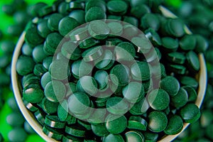 spirulina tablets on green background.Spirulina algae tablets. dietary supplements.Super food .Food supplements for a