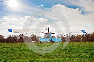 a spitz puppy next to a white light aircraft on the lawn