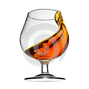 Splash of cognac in glass on white background photo
