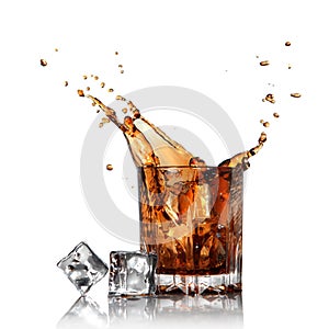 Splash of cola in glass with ice cubes isolated