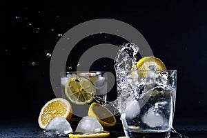 Splash Gin and tonic cocktail with lemon slices Ice cube falls into water with lemon Copy space, lemonade