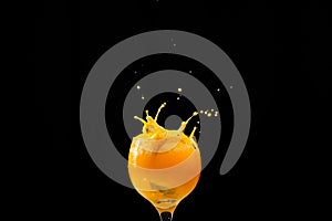 Splash in a glass goblet with orange juice inside